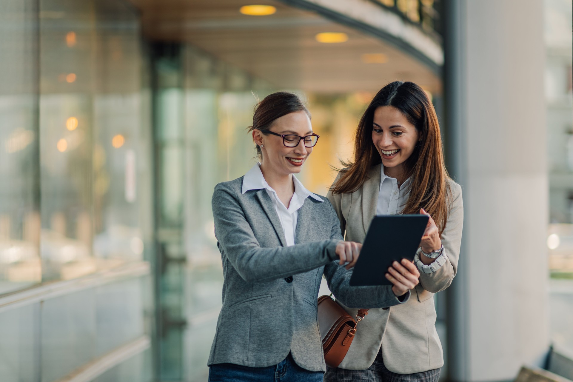 Businesswomen using digital tablet outside office building